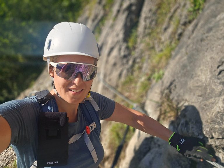 Eva Herz Eine climberin in Helm und Sonnenbrille klettert an einer felsigen Wand.